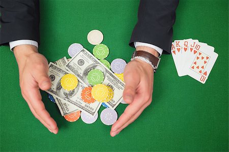 Hands grabbing dollars and chips from table beside royal flush in poker game Stock Photo - Budget Royalty-Free & Subscription, Code: 400-06801884