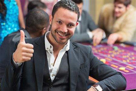 Smiling man thumbs up at the casino at roulette table Foto de stock - Super Valor sin royalties y Suscripción, Código: 400-06801927