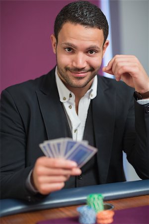 Man holding his cards looking happy Stock Photo - Budget Royalty-Free & Subscription, Code: 400-06801947
