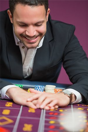 simsearch:400-06802094,k - Man happily grabbing chips at roulette table Foto de stock - Super Valor sin royalties y Suscripción, Código: 400-06801955
