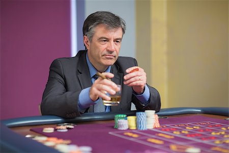 simsearch:400-06802094,k - Man looking at the roulette table looking angry while holding a glass Foto de stock - Super Valor sin royalties y Suscripción, Código: 400-06801956