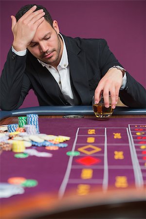 simsearch:400-06802094,k - Man looking dejected at roulette table in casino Foto de stock - Super Valor sin royalties y Suscripción, Código: 400-06801950