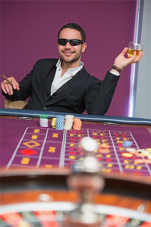 simsearch:400-06802094,k - Man in sunglasses at roulette table holding cigar and glass of whiskey Foto de stock - Super Valor sin royalties y Suscripción, Código: 400-06801953