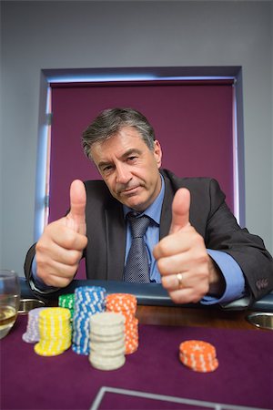 simsearch:400-06802094,k - Man giving thumbs up at roulette table in casino Foto de stock - Super Valor sin royalties y Suscripción, Código: 400-06801967