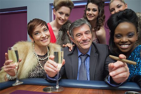 Happy man surrounded by women at roulette table in casino Foto de stock - Super Valor sin royalties y Suscripción, Código: 400-06801976