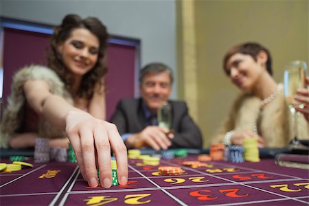 Woman is placing a bet in roulette in casino Foto de stock - Super Valor sin royalties y Suscripción, Código: 400-06801983