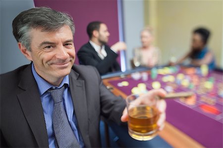 simsearch:400-06802091,k - Man with whiskey glass at roulette table in casino Stock Photo - Budget Royalty-Free & Subscription, Code: 400-06802004