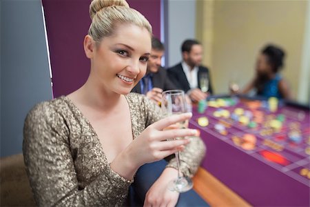 simsearch:400-06802094,k - Blonde lifting champagne glass at roulette table in casino Foto de stock - Super Valor sin royalties y Suscripción, Código: 400-06802005