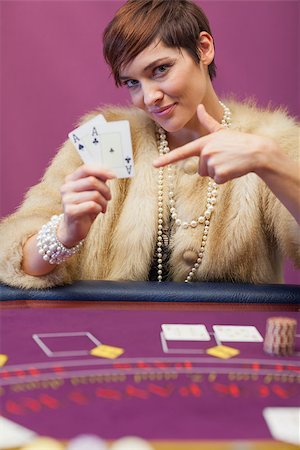 Woman in a casino sitting at table and showing cards Foto de stock - Super Valor sin royalties y Suscripción, Código: 400-06802026