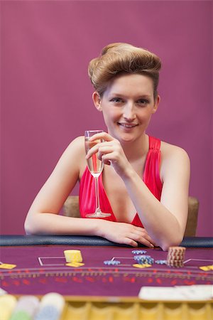Woman sitting at table of a casino holding a glass of champagne Stock Photo - Budget Royalty-Free & Subscription, Code: 400-06802040