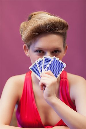 Woman sitting at table in a casino while holding cards before her face Stock Photo - Budget Royalty-Free & Subscription, Code: 400-06802042