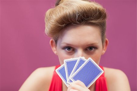 Woman sitting at table in a casino and holding cards up to her face Stock Photo - Budget Royalty-Free & Subscription, Code: 400-06802043