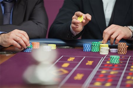 simsearch:400-06802094,k - Two people sitting at table in a casino while placing roulette bets Foto de stock - Super Valor sin royalties y Suscripción, Código: 400-06802092