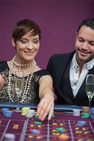 simsearch:400-06802094,k - Woman placing roulette bet with man in casino Foto de stock - Super Valor sin royalties y Suscripción, Código: 400-06802104