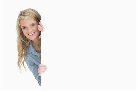 Blonde hiding behind a poster while holding it Stock Photo - Budget Royalty-Free & Subscription, Code: 400-06802234