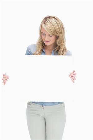 Woman looking at a large piece of paper while holding it Stock Photo - Budget Royalty-Free & Subscription, Code: 400-06802243