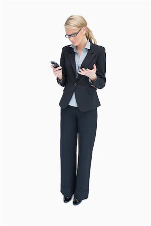 Business woman standing and looking angrily at mobile phone Stock Photo - Budget Royalty-Free & Subscription, Code: 400-06802293