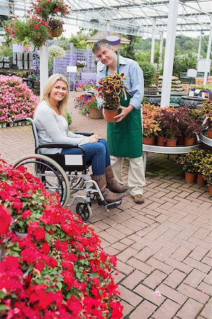 Smiling woman in wheelchair buying a flower in garden centre Stock Photo - Budget Royalty-Free & Subscription, Code: 400-06802676