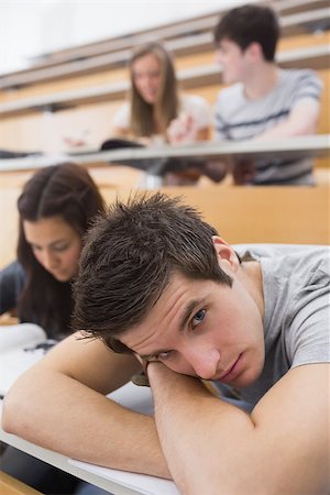 simsearch:400-06803206,k - Student leaning at the desk at the lecture hall having a rest Stock Photo - Budget Royalty-Free & Subscription, Code: 400-06803187