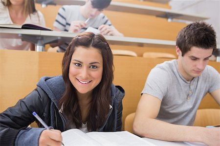 simsearch:400-06803206,k - Student writing at the lecture hall while smiling with classmate Stock Photo - Budget Royalty-Free & Subscription, Code: 400-06803189