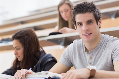 simsearch:400-06803206,k - Student looking up from lecture and smiling with book and pen Stock Photo - Budget Royalty-Free & Subscription, Code: 400-06803183