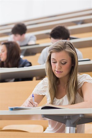 simsearch:400-06803206,k - Woman sitting while writing notes at the lecture hall Stock Photo - Budget Royalty-Free & Subscription, Code: 400-06803199
