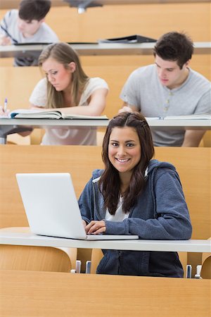 simsearch:400-06803206,k - Smiling student sitting in lecture using laptop Stock Photo - Budget Royalty-Free & Subscription, Code: 400-06803214