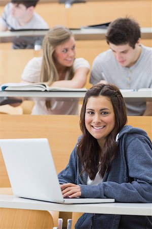 simsearch:400-06803206,k - Girl sitting at the lecture hall smiling with her laptop Stock Photo - Budget Royalty-Free & Subscription, Code: 400-06803215