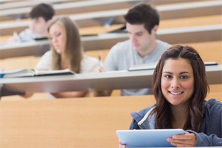 simsearch:400-06803206,k - Smiling student taking notes with tablet pc in lecture hall Stock Photo - Budget Royalty-Free & Subscription, Code: 400-06803210
