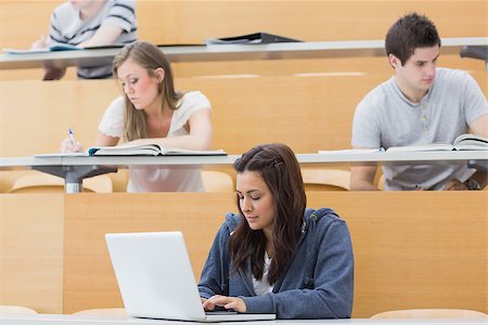 simsearch:400-06803206,k - Students in a lecture hall taking notes with one using laptop Stock Photo - Budget Royalty-Free & Subscription, Code: 400-06803211