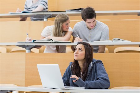simsearch:400-06803206,k - Students sitting at the lecture hall while girl thinking at laptop Stock Photo - Budget Royalty-Free & Subscription, Code: 400-06803212