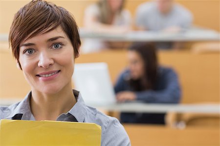 simsearch:400-06803206,k - Teacher standing at the lecture hall while smiling Stock Photo - Budget Royalty-Free & Subscription, Code: 400-06803224
