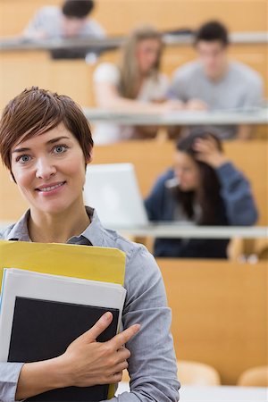 simsearch:400-06803206,k - Teacher standing at the lecture hall holding folders Stock Photo - Budget Royalty-Free & Subscription, Code: 400-06803223