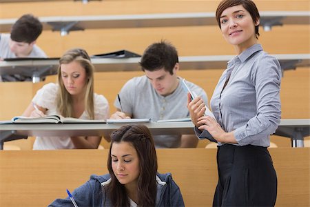 simsearch:400-06803206,k - Students working while teacher smiling in lecture hall Stock Photo - Budget Royalty-Free & Subscription, Code: 400-06803236