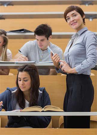 simsearch:400-06803206,k - Students working while teacher smiling at the lecture hall Stock Photo - Budget Royalty-Free & Subscription, Code: 400-06803237