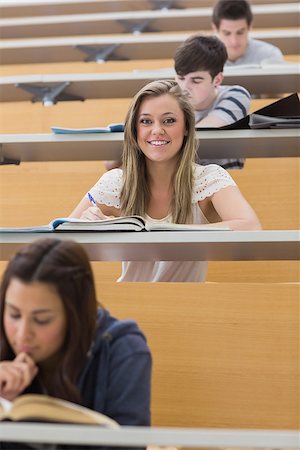 simsearch:400-06803206,k - Student sitting at the lecture hall smiling and taking notes Stock Photo - Budget Royalty-Free & Subscription, Code: 400-06803238