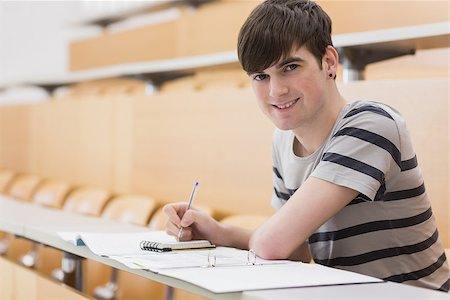 simsearch:400-06803206,k - Student sitting at the lecture hall while holding a pen and smiling Stock Photo - Budget Royalty-Free & Subscription, Code: 400-06803255