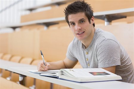 simsearch:400-06803206,k - Student sitting at the desk while smiling in lecture hall Stock Photo - Budget Royalty-Free & Subscription, Code: 400-06803250