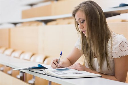 simsearch:400-06803206,k - Concentrating woman sitting at the lecture hall while writing out notes Stock Photo - Budget Royalty-Free & Subscription, Code: 400-06803260