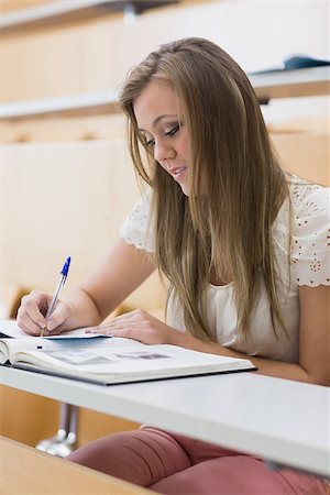 simsearch:400-06803206,k - Focused student sitting at the lecture hall writing notes Stock Photo - Budget Royalty-Free & Subscription, Code: 400-06803261