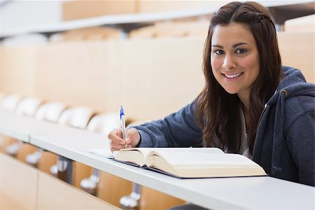 simsearch:400-06803206,k - Girl sitting smiling while reading a book and taking notes at the lecture hall Stock Photo - Budget Royalty-Free & Subscription, Code: 400-06803263