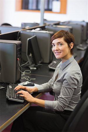 simsearch:400-07267978,k - Teacher sitting at the computer room while smiling Stock Photo - Budget Royalty-Free & Subscription, Code: 400-06803275