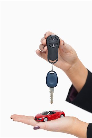 Woman holding key and small car against white background Stock Photo - Budget Royalty-Free & Subscription, Code: 400-06803441