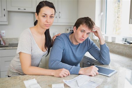 simsearch:400-06803524,k - Two people in the kitchen are calculating the finances with an ebook Stock Photo - Budget Royalty-Free & Subscription, Code: 400-06803528