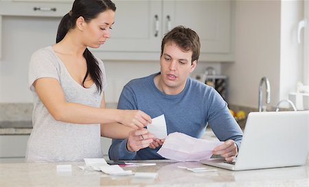 simsearch:400-06803524,k - Couple talking about bills with laptop in kitchen Stock Photo - Budget Royalty-Free & Subscription, Code: 400-06803538