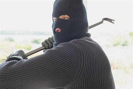 Burglar holding a crowbar and winding up while being in a house Stock Photo - Budget Royalty-Free & Subscription, Code: 400-06803576