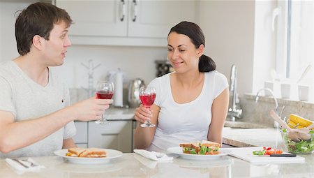 Young couple drinking wine and eating sandwiches while sitting in the kitchen Stock Photo - Budget Royalty-Free & Subscription, Code: 400-06803589