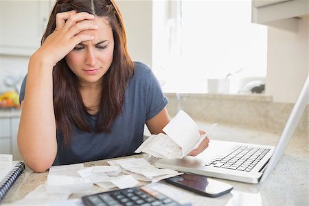 simsearch:400-06803524,k - Brunette looking worried over bills in kitchen Stock Photo - Budget Royalty-Free & Subscription, Code: 400-06803664