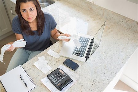 simsearch:400-06803524,k - Young woman calculating bills and looking worried in kitchen Stock Photo - Budget Royalty-Free & Subscription, Code: 400-06803669