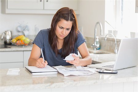 simsearch:400-06803524,k - Brunette woman calculating bills in the kitchen Stock Photo - Budget Royalty-Free & Subscription, Code: 400-06803675